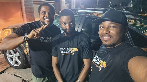 The crew by the wrapped car at the market